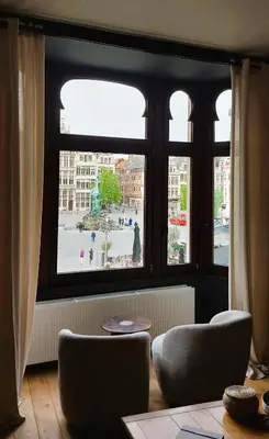 a living room with a large window and two chairs at Diamond - room with a view in Antwerp