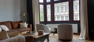 a living room with a couch and chairs and a large window at Diamond - room with a view in Antwerp
