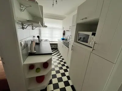 a white kitchen with a black and white checkered floor at Spacious 2 Bedroom App in the Center with Balcony in Ghent