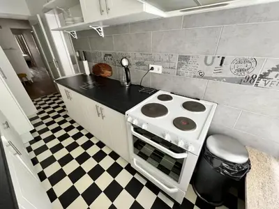 a kitchen with a stove and a checkered floor at Spacious 2 Bedroom App in the Center with Balcony in Ghent