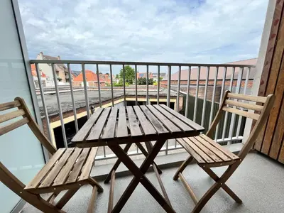 a wooden table and two chairs on a balcony at Spacious 2 Bedroom App in the Center with Balcony in Ghent