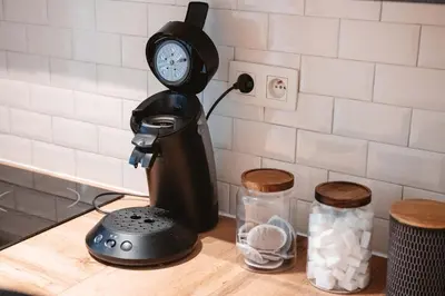a kitchen counter with a coffee maker and a clock at K-suites in Brussels