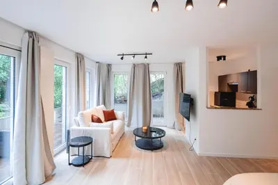 a living room with white furniture and large windows at K-suites in Brussels