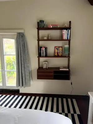 a bedroom with a bed and a book shelf at Charmante maison dans un coin de verdure à Boitsfort in Brussels