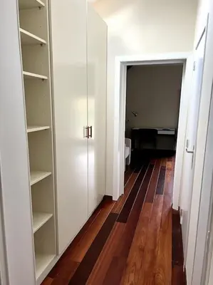 a hallway with white cabinets and a wooden floor at Charmante maison dans un coin de verdure à Boitsfort in Brussels