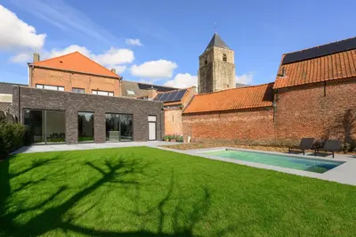 a large yard with a swimming pool in front of a building at Huis Velzeke in Zottegem