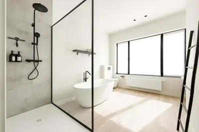 a bathroom with a tub and a shower with a window at Huis Velzeke in Zottegem