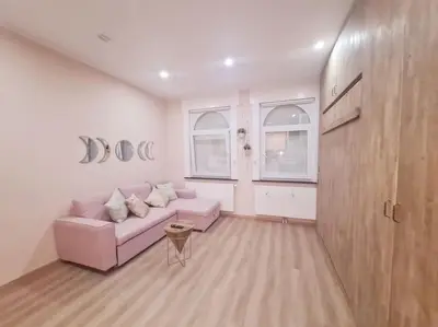 a living room with a pink couch and two windows at Magnolia Pink Studio New and fully equipped in Brussels