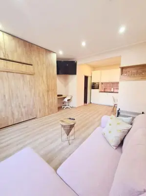 a living room with a white couch and a kitchen at Magnolia Pink Studio New and fully equipped in Brussels