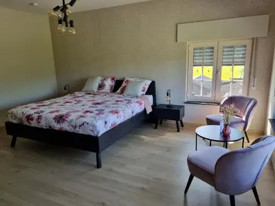 a bedroom with a bed and a table and chairs at B&B Krieken de Jour in Ninove