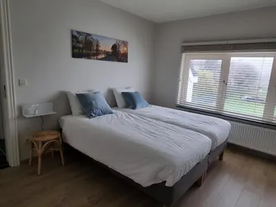 a bedroom with a large bed with blue pillows at B&B Krieken de Jour in Ninove