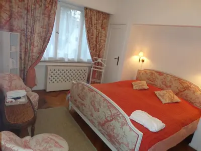 a bedroom with a bed and a chair and a window at B&B Capitaine Piret in Brussels