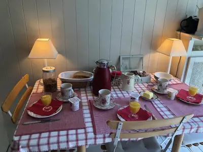 a table with a red and white table cloth with cups and plates at B&B Capitaine Piret in Brussels