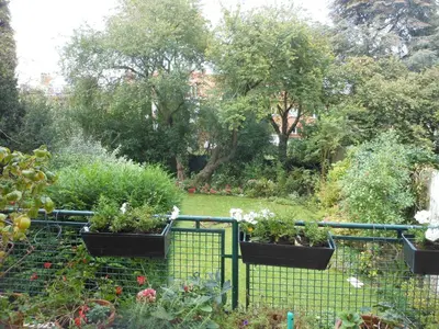 a garden with potted plants on a fence at B&B Capitaine Piret in Brussels