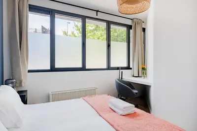 a bedroom with a bed and a desk and a window at Brussels EU Design Residence in Brussels