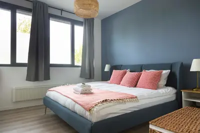a bedroom with blue walls and a bed with pink pillows at Brussels EU Design Residence in Brussels