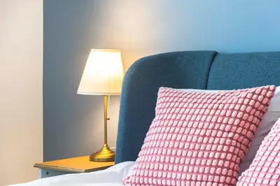 a bed with a pink pillow next to a lamp at Brussels EU Design Residence in Brussels