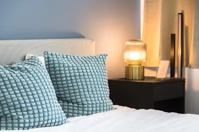 a bed with two pillows and a lamp on it at Brussels EU Design Residence in Brussels
