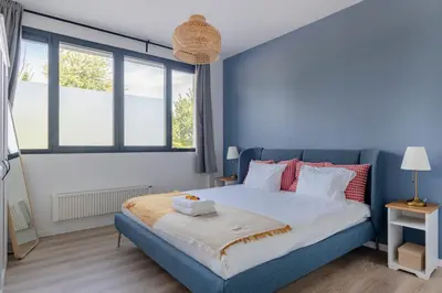 a bedroom with a blue bed and windows at Brussels EU Design Residence in Brussels