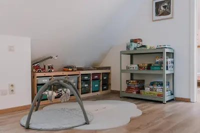 a room with a play area with a table and shelves at Vakantiehuis De Bekaf in Stekene