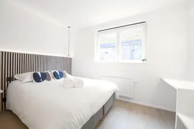 a white bedroom with a large bed and a window at WoW in Brussels