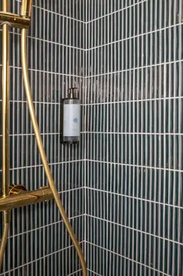 a bathroom with a tile wall with a soap dispenser at WoW in Brussels