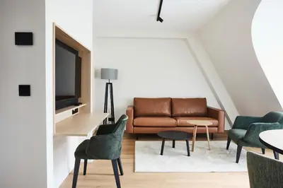 a living room with a couch and chairs at Georges Henri Aparthotel in Brussels