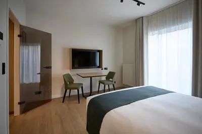 a bedroom with a bed and a table and chairs at Georges Henri Aparthotel in Brussels