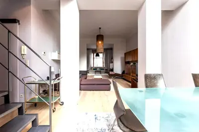 a dining room with a glass table and stairs at Spacious apartment in Brussels, large private garden in Brussels