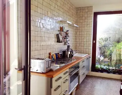 a kitchen with a stove and a sink and a window at Spacious apartment in Brussels, large private garden in Brussels