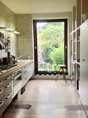 a kitchen with a large window and a table at Spacious apartment in Brussels, large private garden in Brussels
