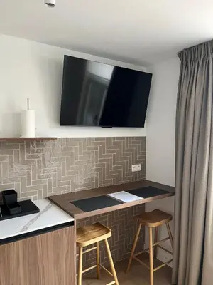 a desk with two stools and a television on a wall at Business Accommodation 'Natural Living' Nomad in Geel