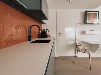 a kitchen with a sink and a chair next to a counter at Business Accommodation 'Flow Living' Nomad in Geel