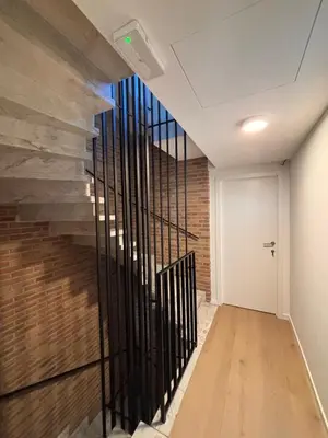 a hallway with a staircase with a brick wall at Business Accommodation 'Flow Living' Nomad in Geel