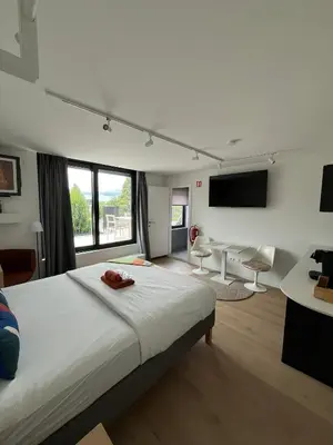 a bedroom with a large bed and a living room at Business Accommodation 'Urban Living' Intimate in Geel