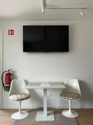 a white table with two chairs and a tv on a wall at Business Accommodation 'Urban Living' Intimate in Geel