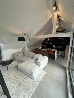 a living room with a white couch and a table at Business Accommodation 'Loft' Intimate in Geel