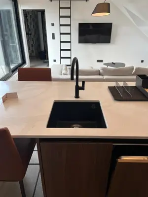 a kitchen with a sink and a living room at Business Accommodation 'Loft' Intimate in Geel