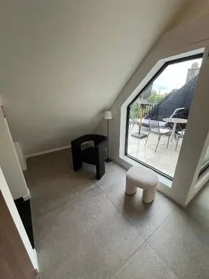 a room with a window and a chair and a table at Business Accommodation 'Loft' Intimate in Geel