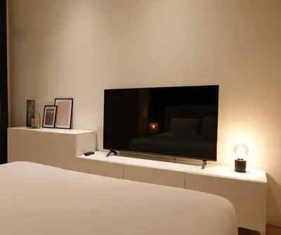 a bedroom with a large flat screen tv on a wall at Luxury Apartment with Cosy Garden! in Ghent