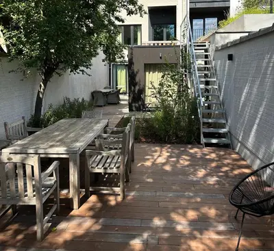 a wooden table and chairs on a patio at Luxury Apartment with Cosy Garden! in Ghent