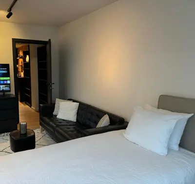a bedroom with a couch and a bed with white pillows at Luxury Apartment with Cosy Garden! in Ghent