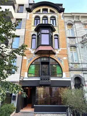 a large brick building with a balcony on it at Luxury Apartment with Cosy Garden! in Ghent