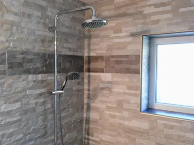 a shower with a glass door and a window at VILLA EXPO in Brussels