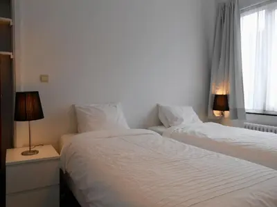 two beds sitting next to a window in a bedroom at VILLA EXPO in Brussels