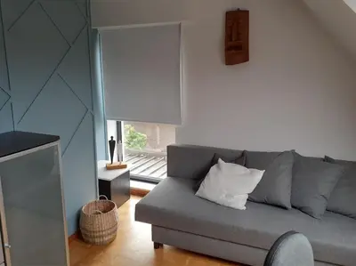 a living room with a gray couch and a window at Huis met 4 slaapkamers tussen Antwerpen en Brussel in Rumst