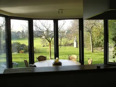 a dining room with a table and a large window at Huis met 4 slaapkamers tussen Antwerpen en Brussel in Rumst