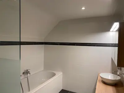 a white bathroom with a tub and a sink at Molenbaan28 in Merchtem