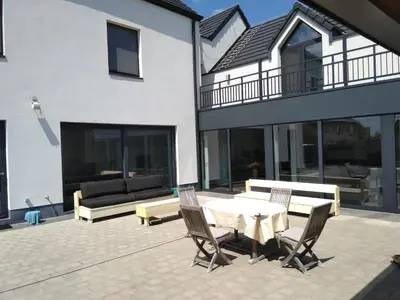 a patio with a table and chairs and a couch at Molenbaan28 in Merchtem