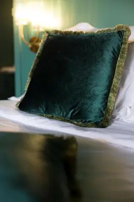 a green pillow sitting on top of a bed at Atelier K - Art Guesthouse in Brussels in Brussels